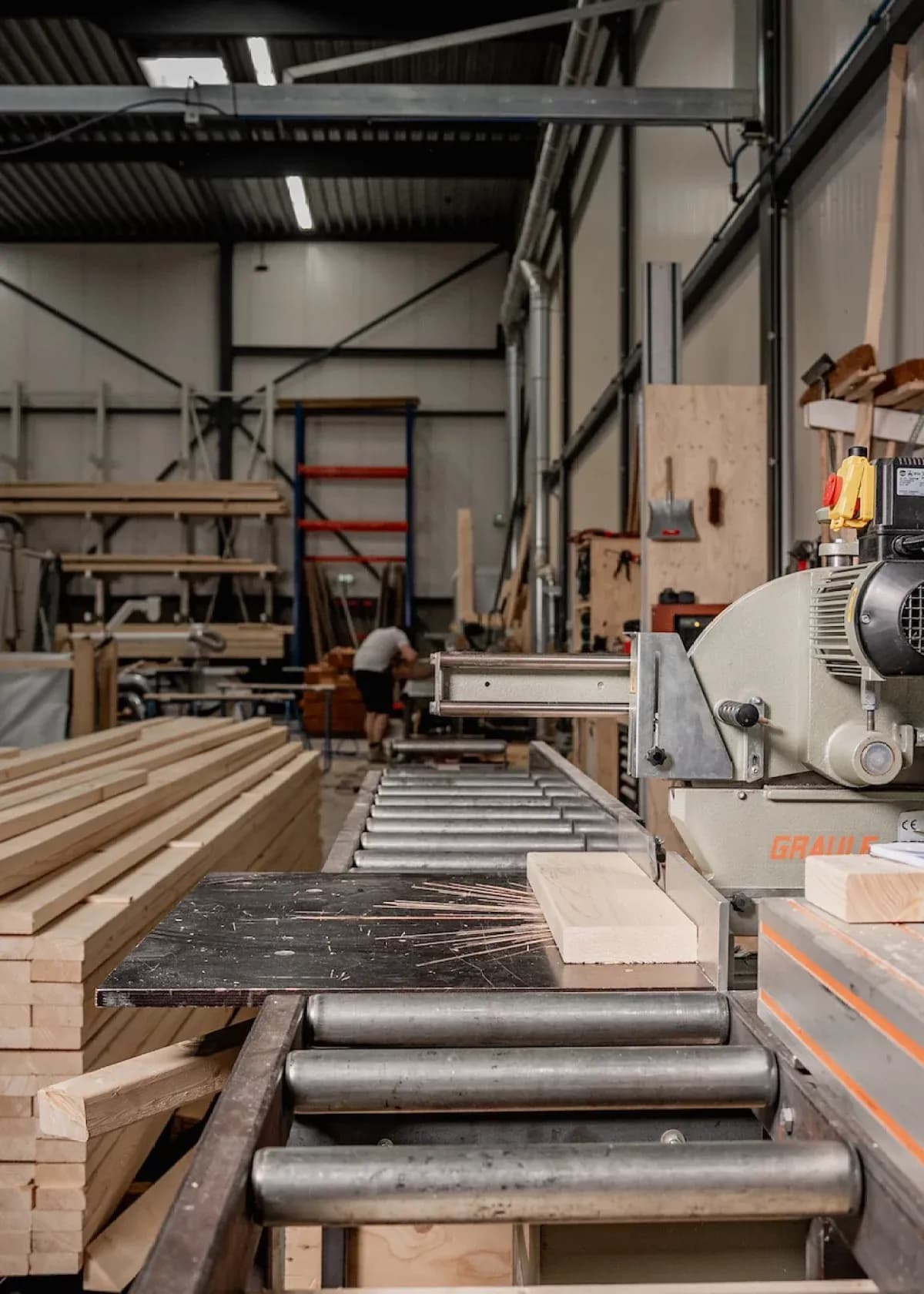 Houtbewerkingsmachine die houten plank op transportband verwerkt in een werkplaats
