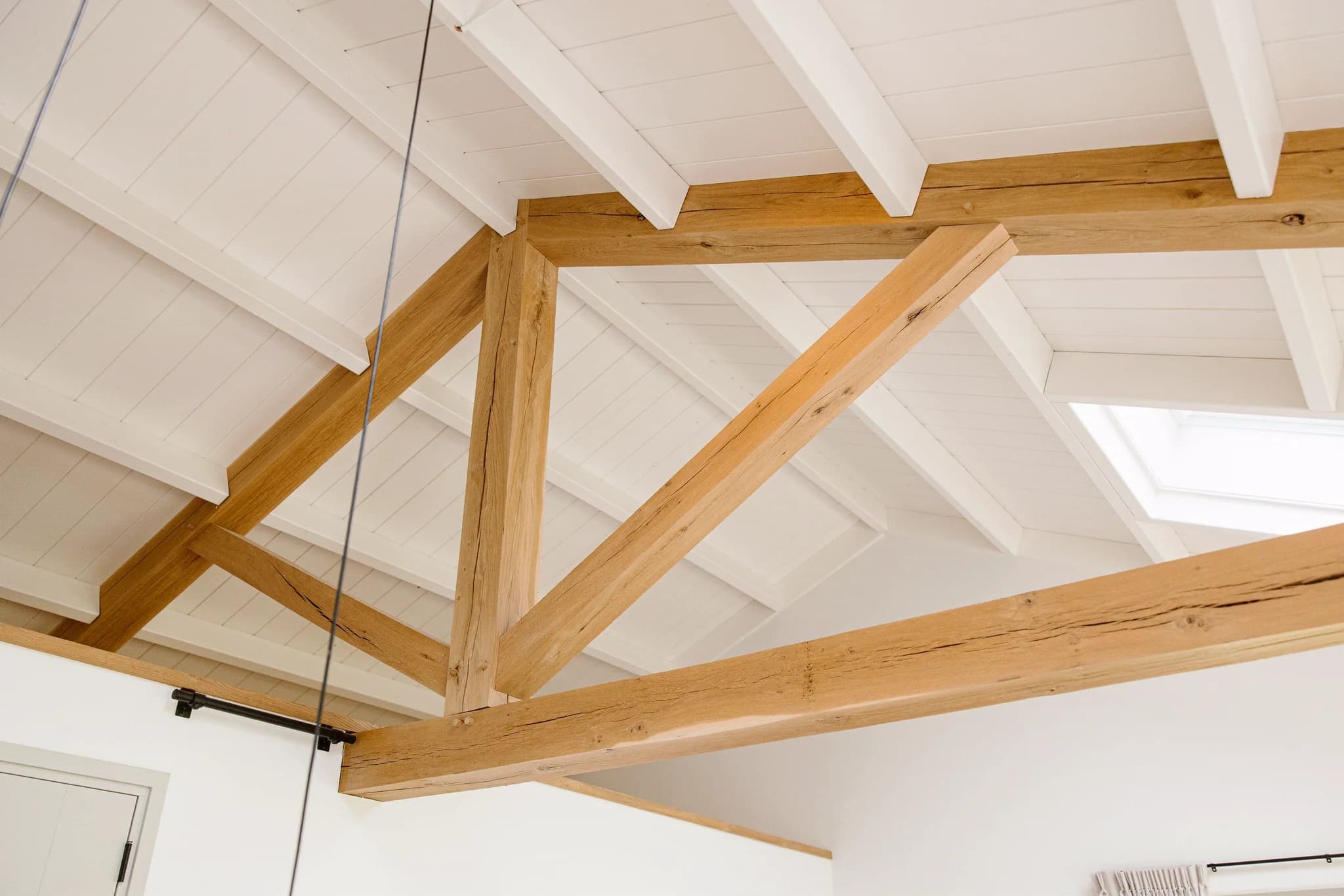 Witte zolder met houten balkenstructuur en dakraam